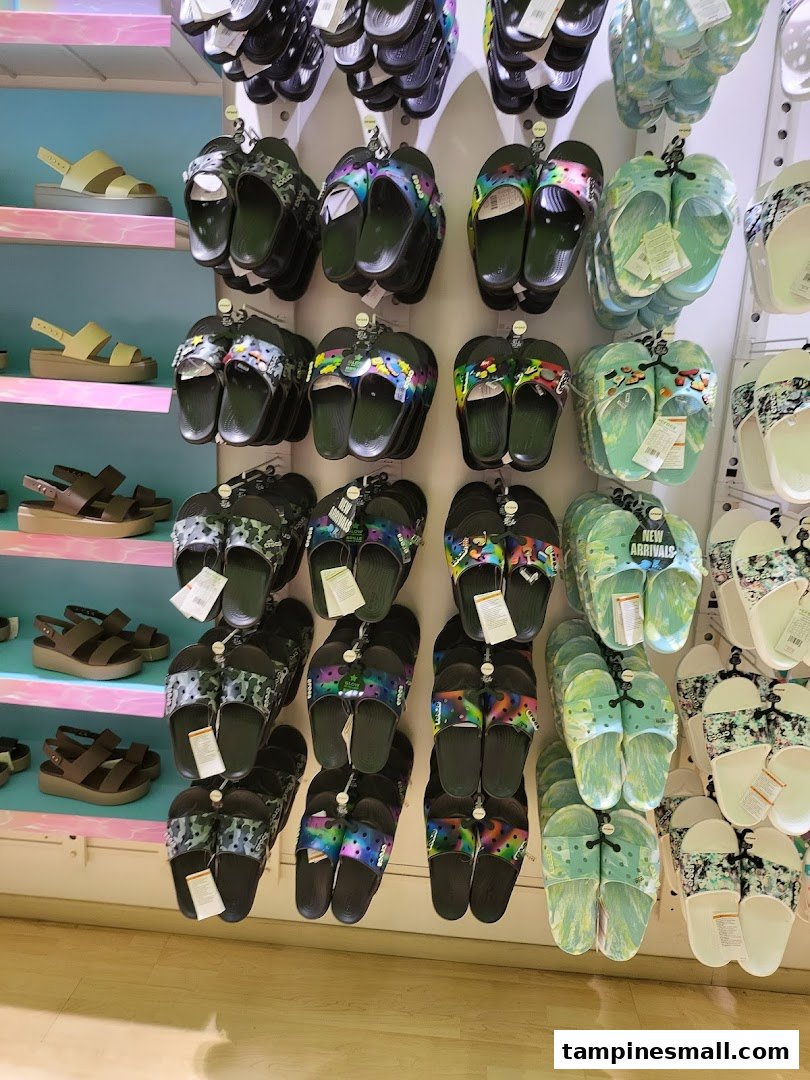 A vibrant display of Crocs sandals and slides in various colors and patterns.