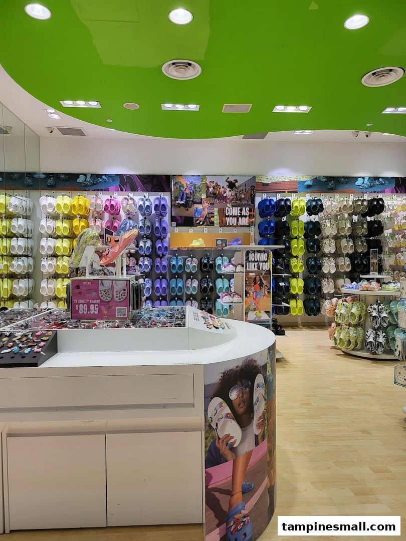Vibrant interior of a Crocs store showcasing colorful clogs, sandals, and Jibbitz charms on display.