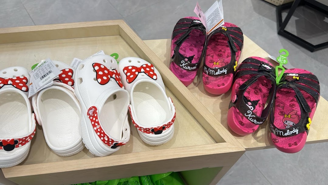 Close-up of Crocs shoes and sandals featuring popular character designs like Minnie Mouse, Kuromi, and My Melody.