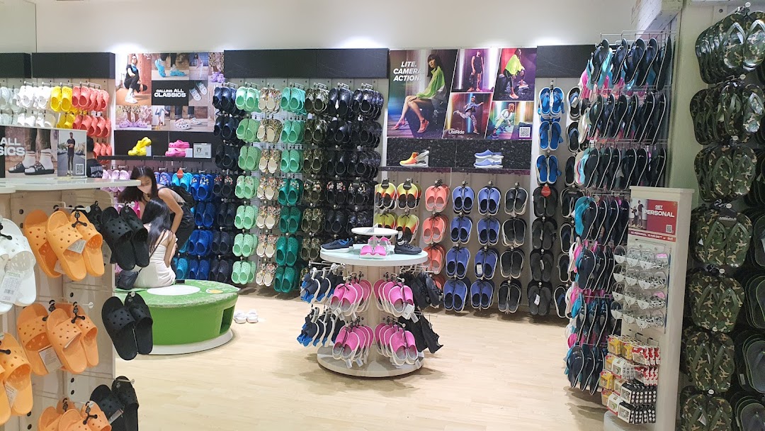 Interior view of a Crocs store showcasing a wide variety of colorful footwear and accessories.