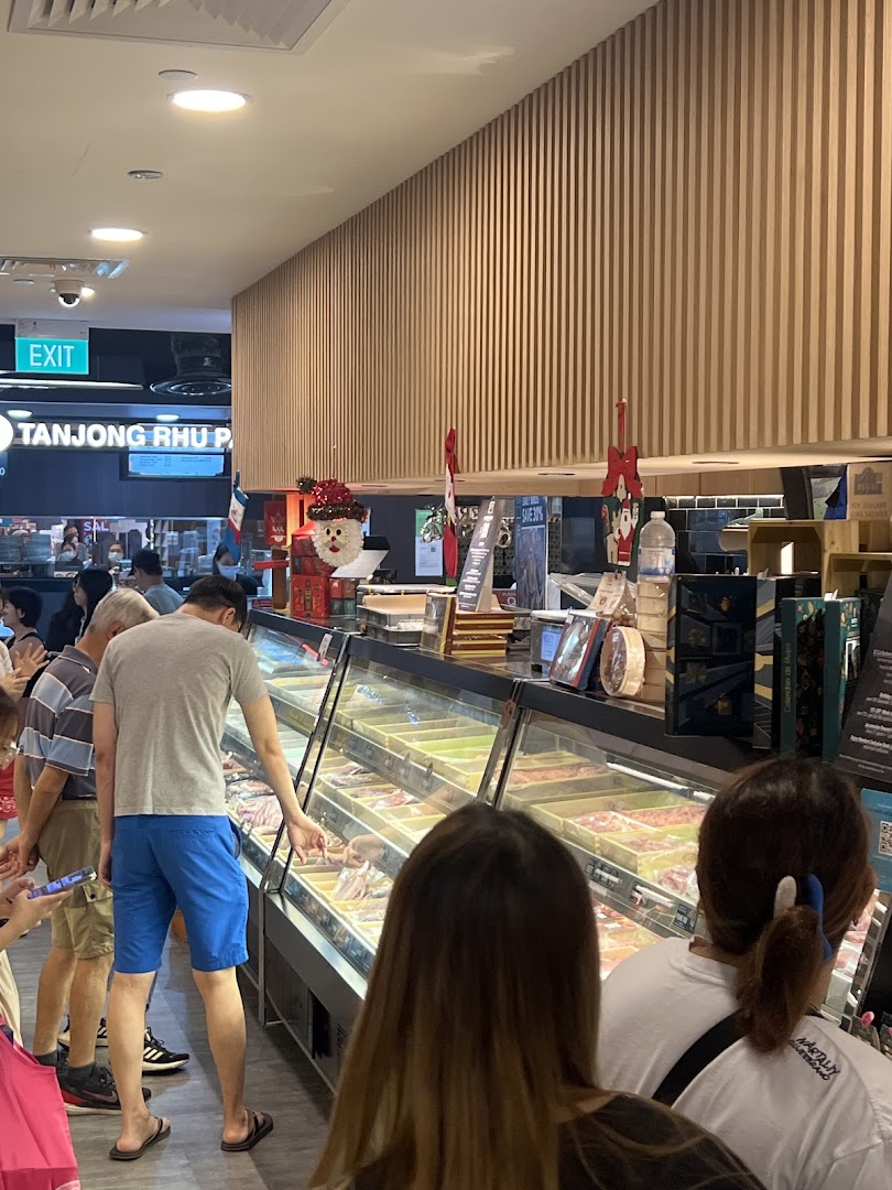 Customers browse a refrigerated display counter filled with fresh meat products inside Cut Butchery.