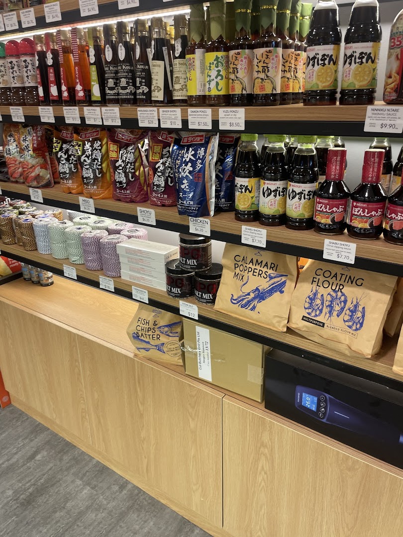 Shelves stocked with Japanese sauces, cooking mixes, and gourmet food items, offering diverse culinary ingredients.