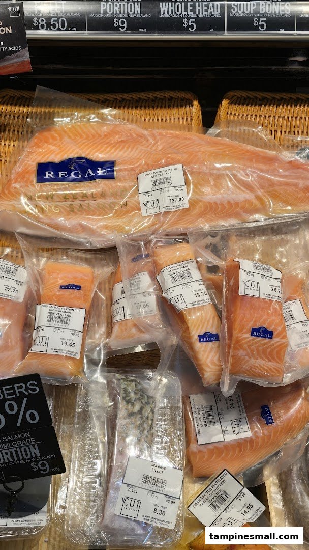 Various cuts of fresh, packaged salmon and other seafood displayed in a retail chiller.