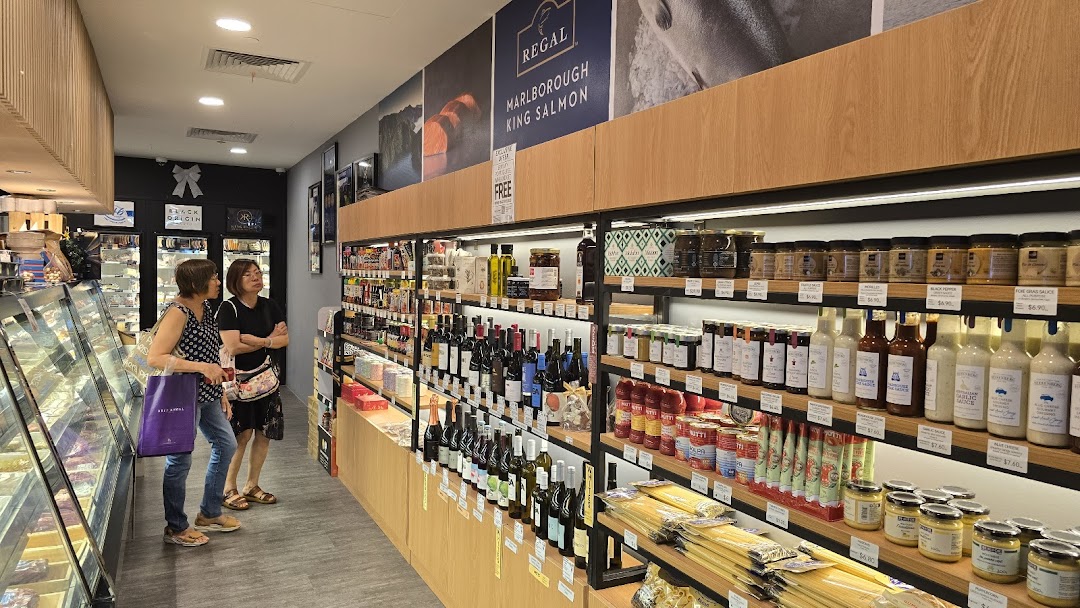 Customers browse a wide selection of gourmet foods, wines, and fresh produce inside Cut Butchery.