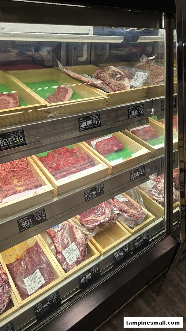 A refrigerated display case showcasing various cuts of fresh meat with clear price labels.