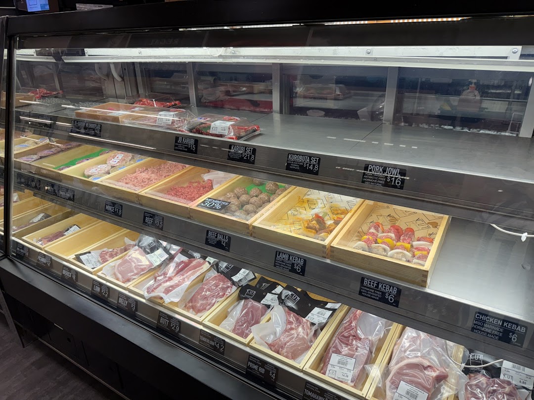 A well-stocked refrigerated display case at Cut Butchery, featuring various fresh meat cuts and prepared items.