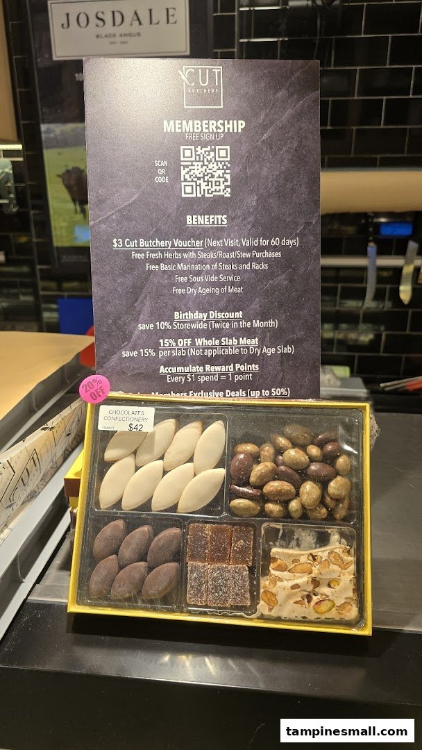 A membership benefits sign and a gourmet confectionery box displayed at Cut Butchery.
