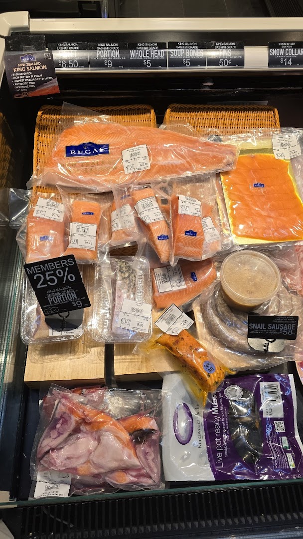 A refrigerated display case showcasing packaged fresh salmon, seafood, and specialty meats at Cut Butchery.