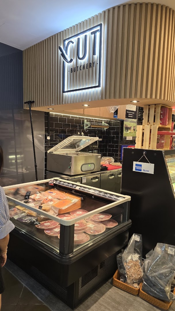 Interior view of Cut Butchery, showcasing fresh meat displays and the illuminated brand sign.