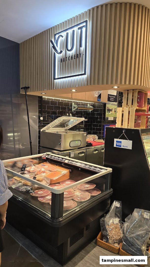 Interior view of Cut Butchery, showcasing fresh meat displays and the illuminated brand sign.