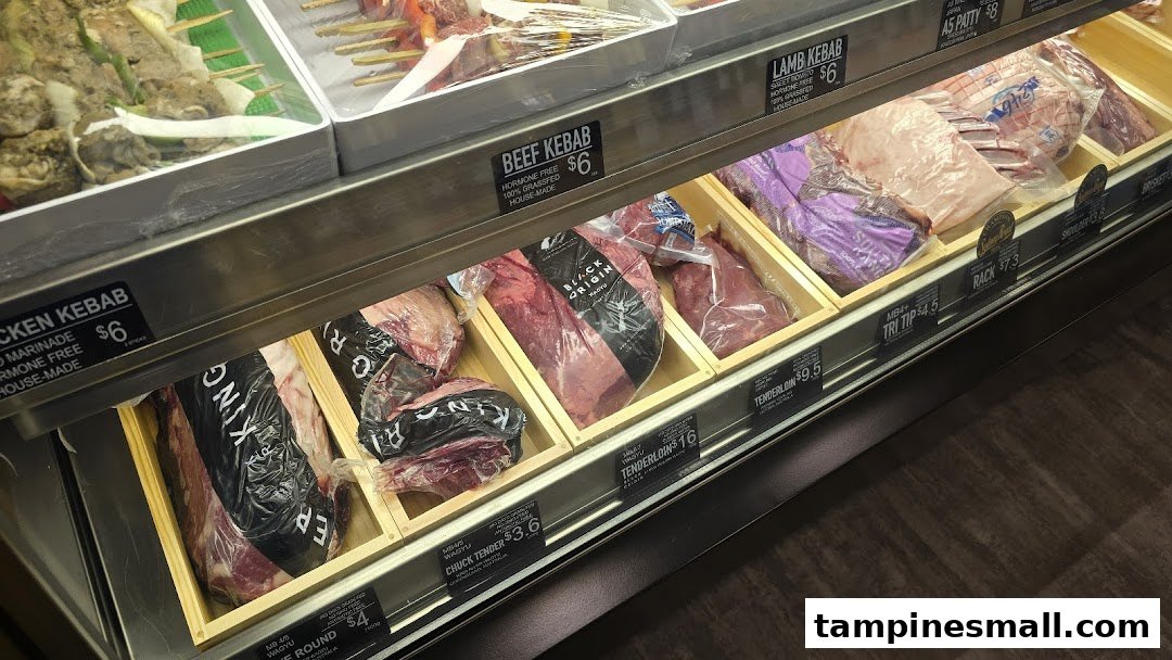 A display case showcasing various fresh meat cuts and kebabs with price labels at Cut Butchery.