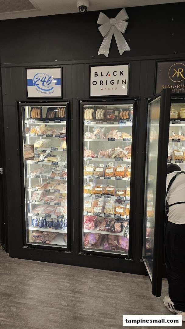 Inside Cut Butchery, showcasing refrigerated displays filled with various packaged meats and sausages.