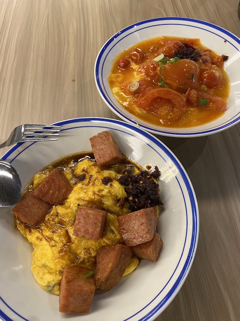 Two delicious bowls of scrambled egg rice dishes, one with luncheon meat, the other with tomato sauce.