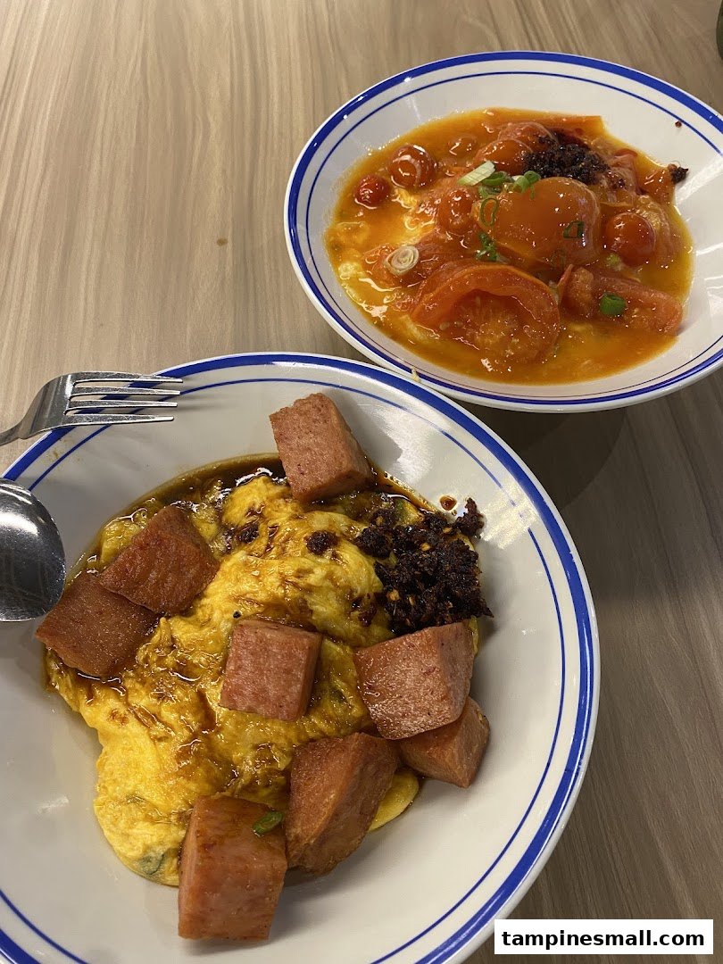 Two delicious bowls of scrambled egg rice dishes, one with luncheon meat, the other with tomato sauce.