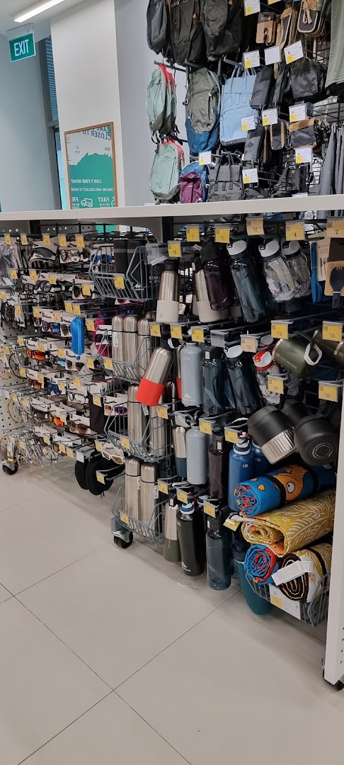 An aisle in Decathlon showcasing a variety of sports accessories like backpacks, water bottles, and sunglasses.