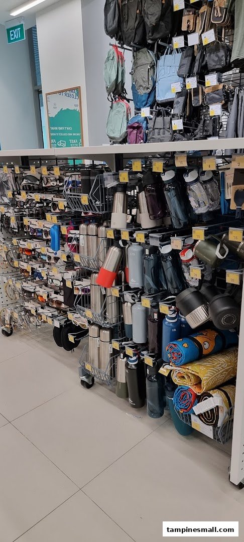 An aisle in Decathlon showcasing a variety of sports accessories like backpacks, water bottles, and sunglasses.