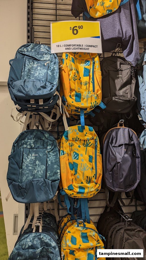 A display of colorful Decathlon backpacks, including patterned and solid designs, with a visible price tag.