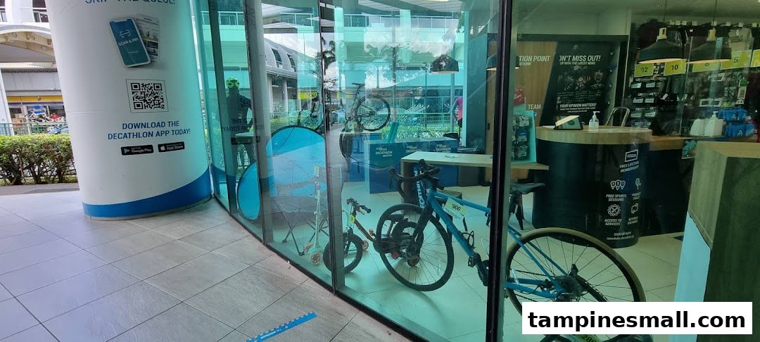 The glass facade of Decathlon, showcasing bicycles and an app download sign at the entrance.