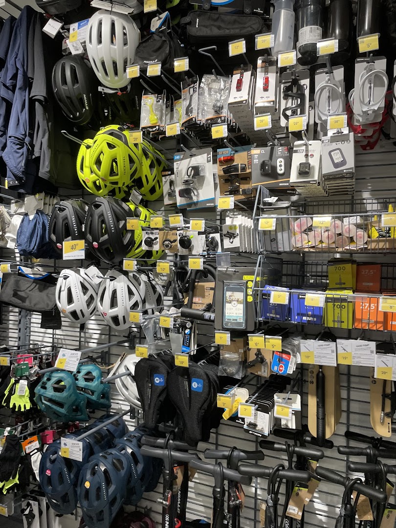 A wall display at Decathlon showcasing a wide range of cycling helmets, accessories, and equipment.