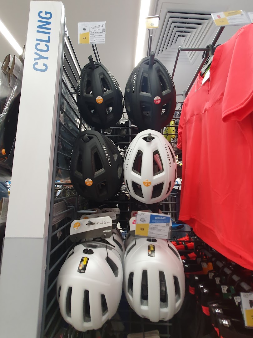 A display of cycling helmets and apparel in Decathlon's sports gear section.