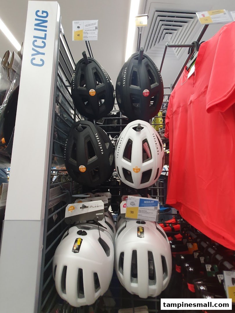 A display of cycling helmets and apparel in Decathlon's sports gear section.