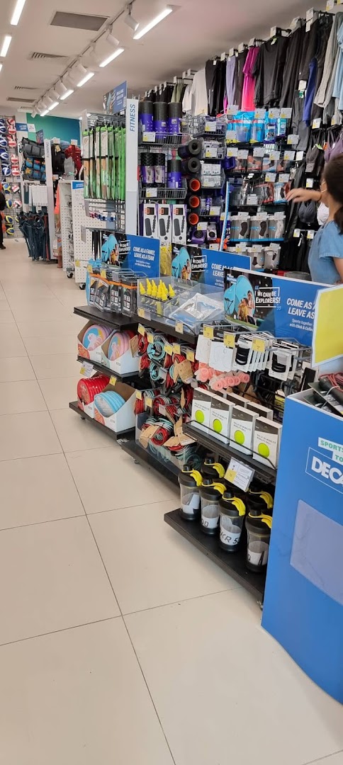An aisle inside Decathlon showcasing various sports apparel, fitness equipment, and accessories.