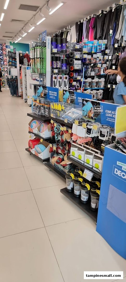 An aisle inside Decathlon showcasing various sports apparel, fitness equipment, and accessories.