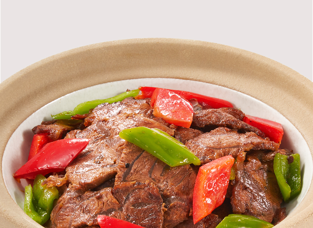 A close-up of a delicious beef dish with vibrant red and green bell peppers.