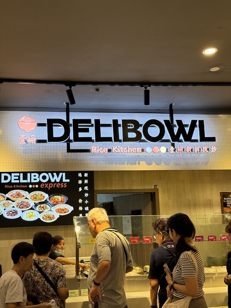 Customers queueing at the Delibowl Rice Kitchen counter, featuring their illuminated signage and food display.