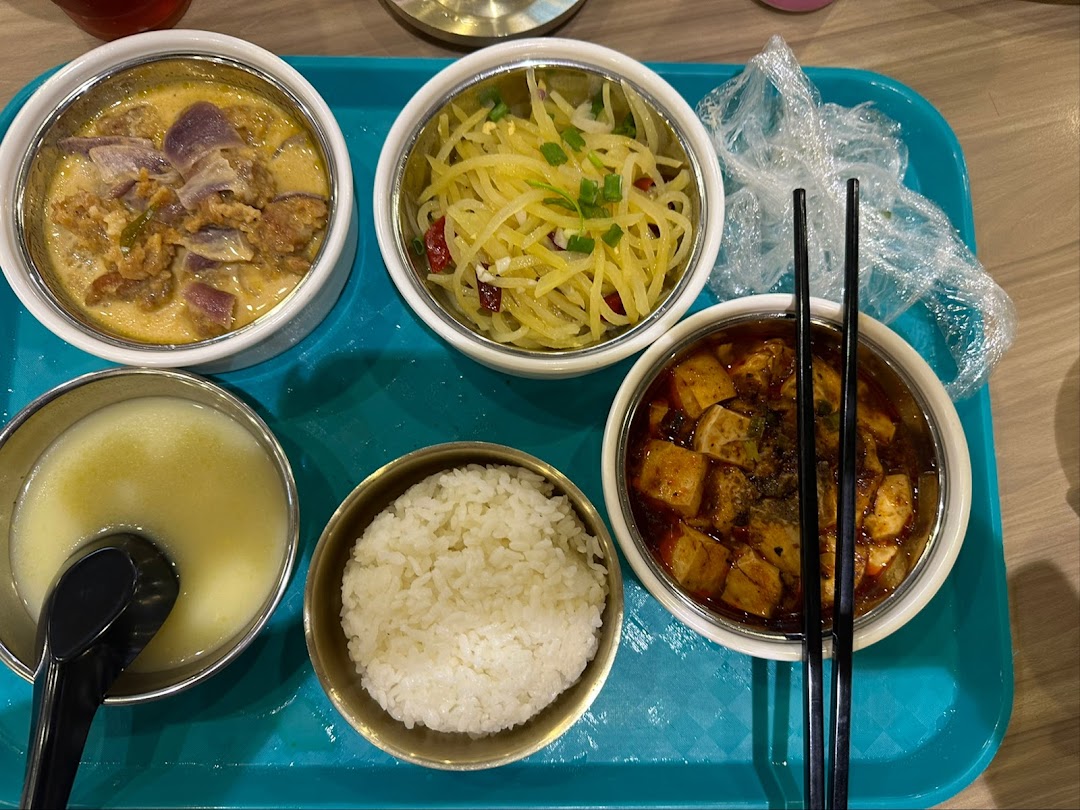 A vibrant tray of Asian dishes including rice, soup, and various main courses.