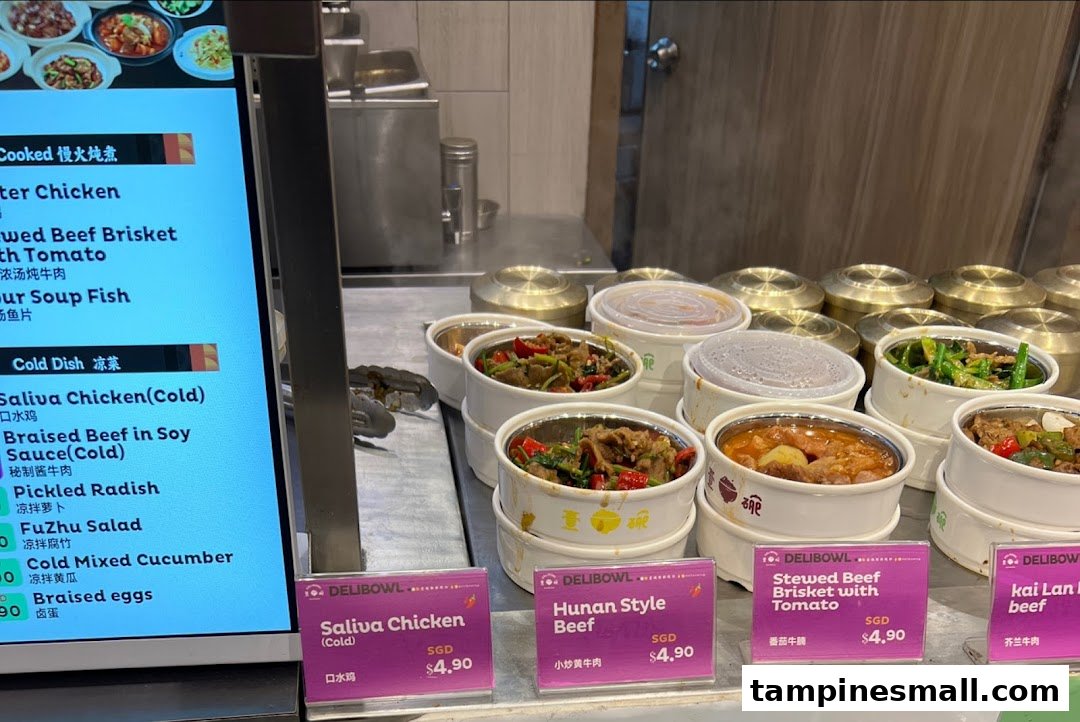 A digital menu board and a display of various hot and cold dishes in containers.