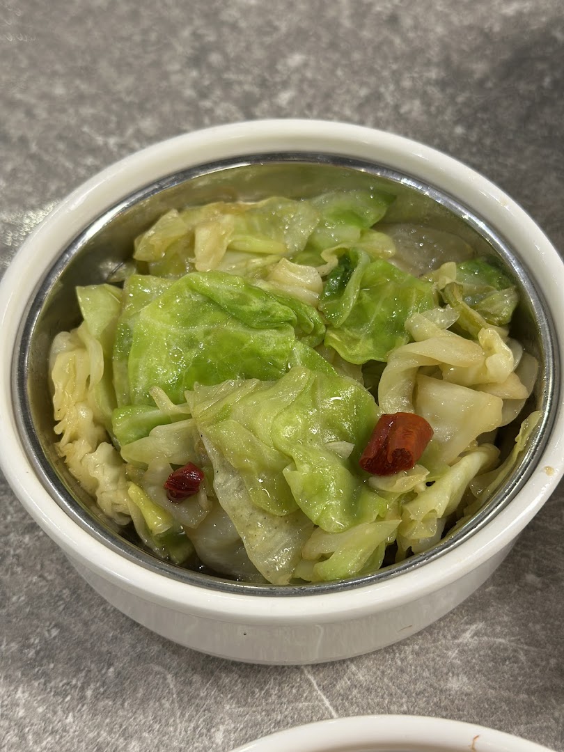 A close-up of a bowl of stir-fried cabbage with chili, a delicious side dish.