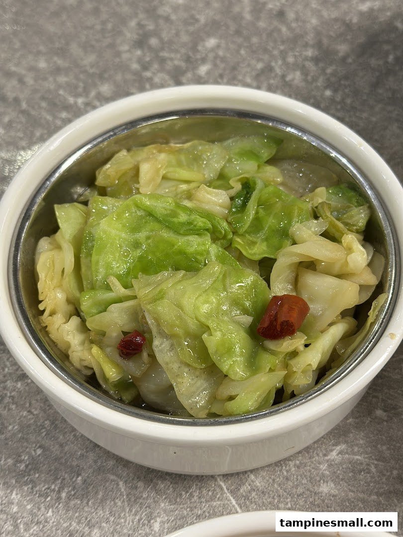 A close-up of a bowl of stir-fried cabbage with chili, a delicious side dish.