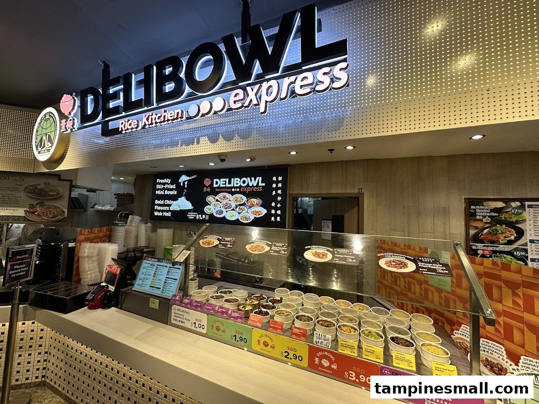The illuminated storefront and counter of Delibowl Rice Kitchen Express, showcasing food displays.
