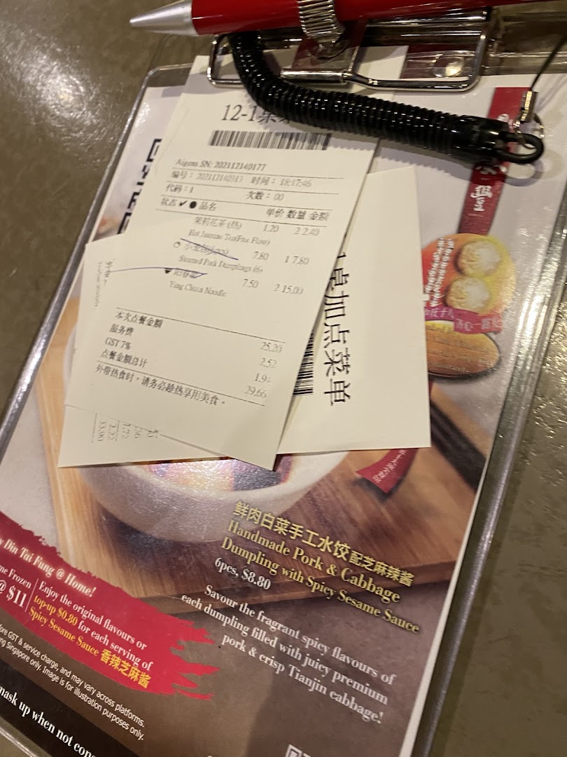 A close-up of a Din Tai Fung order pad and bill, featuring menu items and pricing.