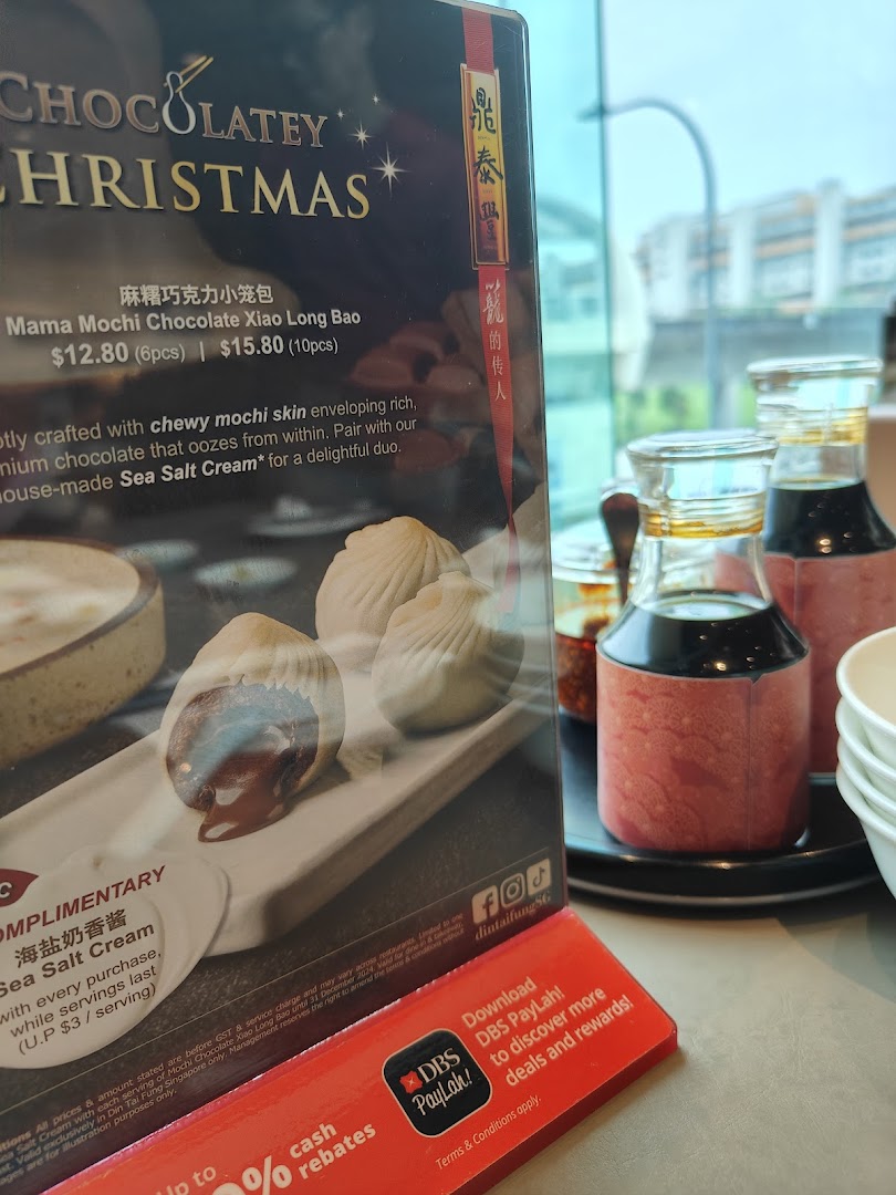 A promotional menu stand for Din Tai Fung's Mama Mochi Chocolate Xiao Long Bao with condiments.