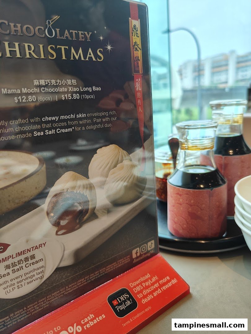A promotional menu stand for Din Tai Fung's Mama Mochi Chocolate Xiao Long Bao with condiments.