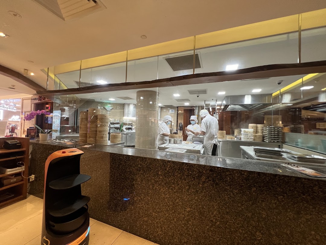 Chefs prepare dim sum in Din Tai Fung's open kitchen, showcasing culinary artistry.
