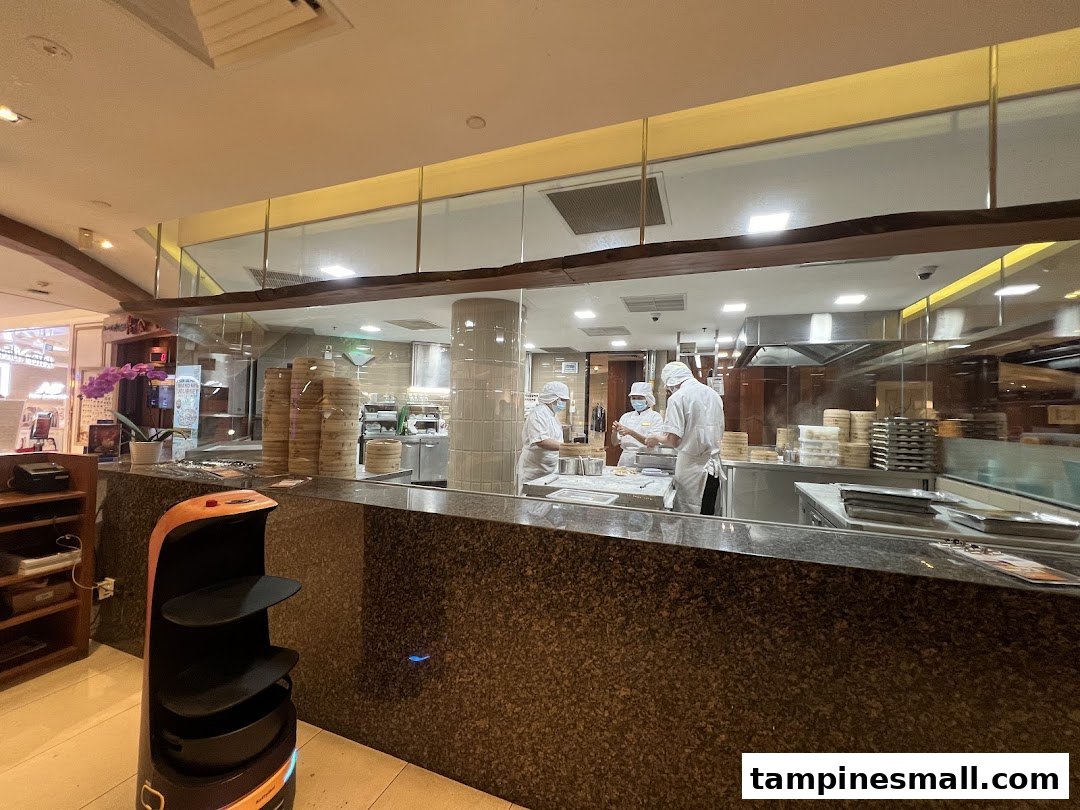 Chefs prepare dim sum in Din Tai Fung's open kitchen, showcasing culinary artistry.
