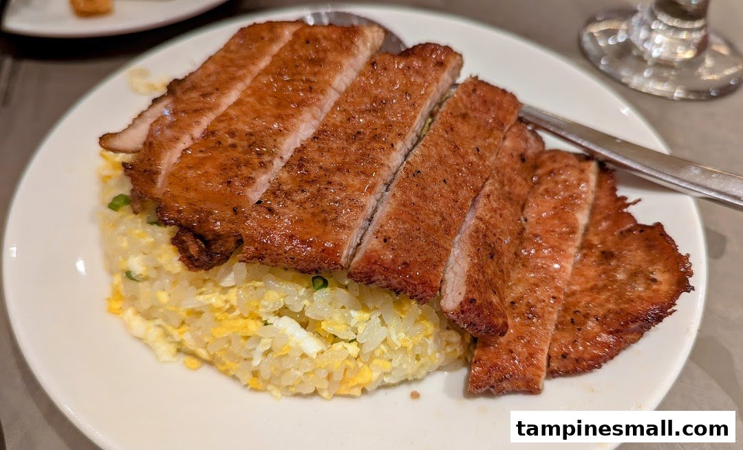 A delicious plate of sliced pork chop served over golden fried rice.