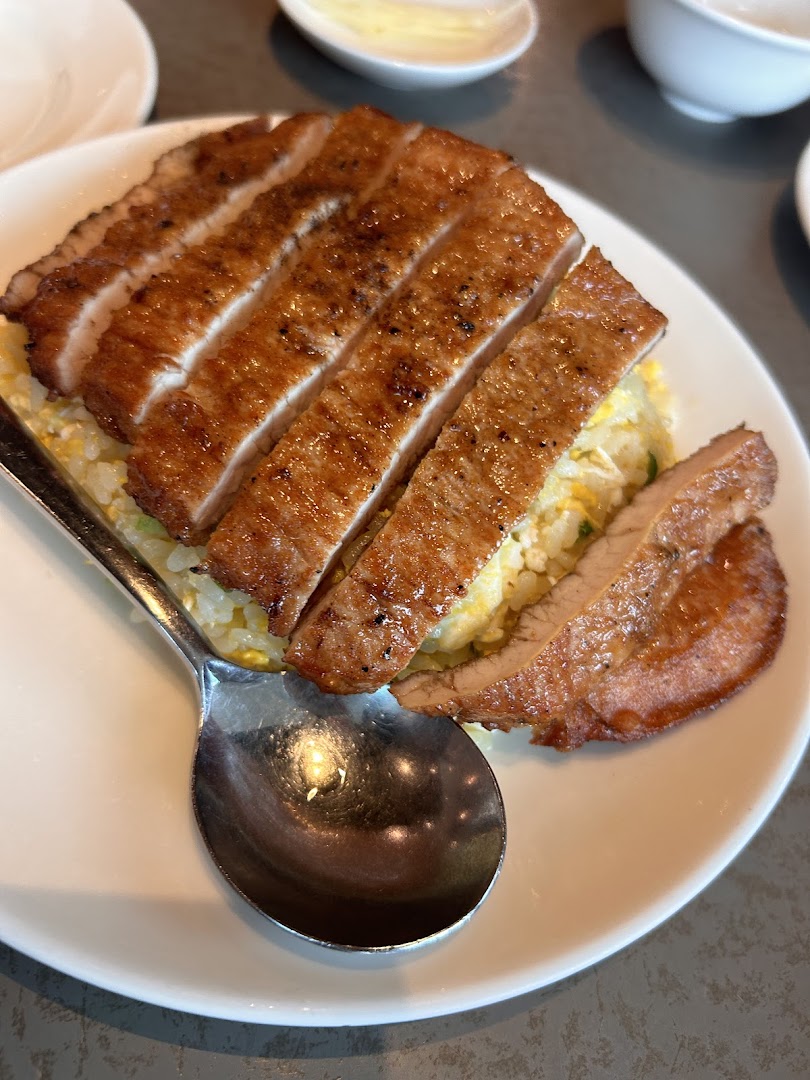 A close-up of Din Tai Fung's signature pork chop fried rice on a white plate.
