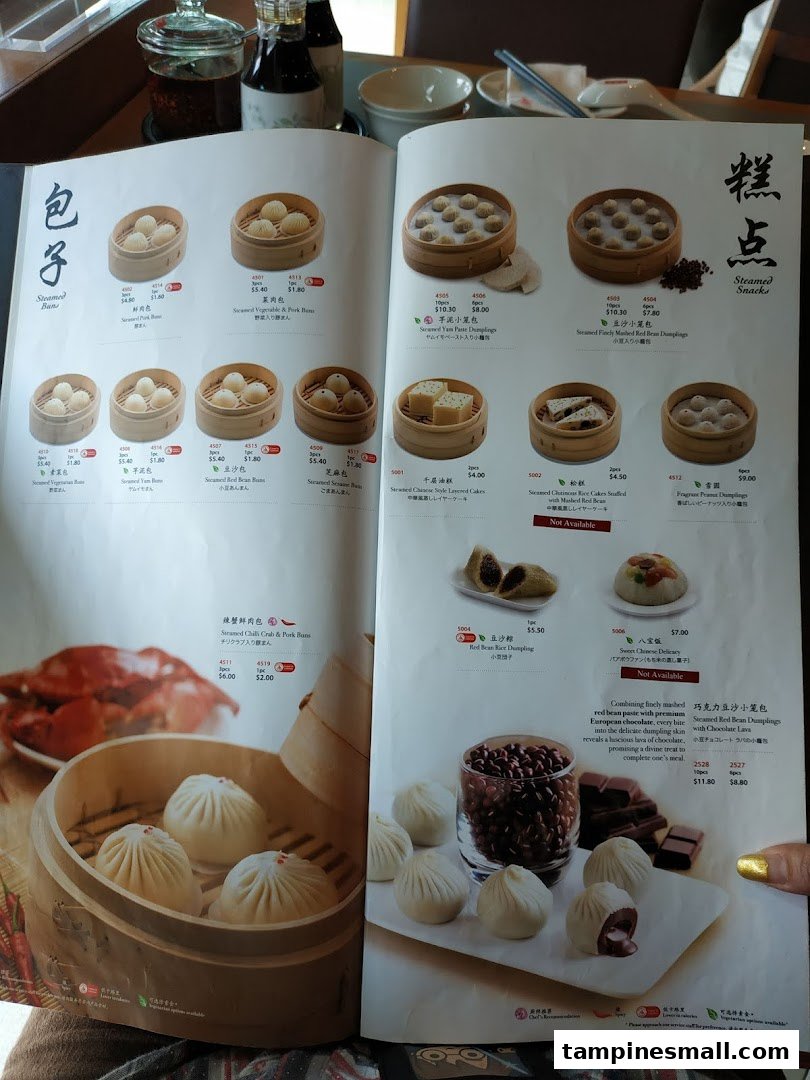 A detailed menu from Din Tai Fung, showcasing a variety of steamed buns and snacks with prices and descriptions.