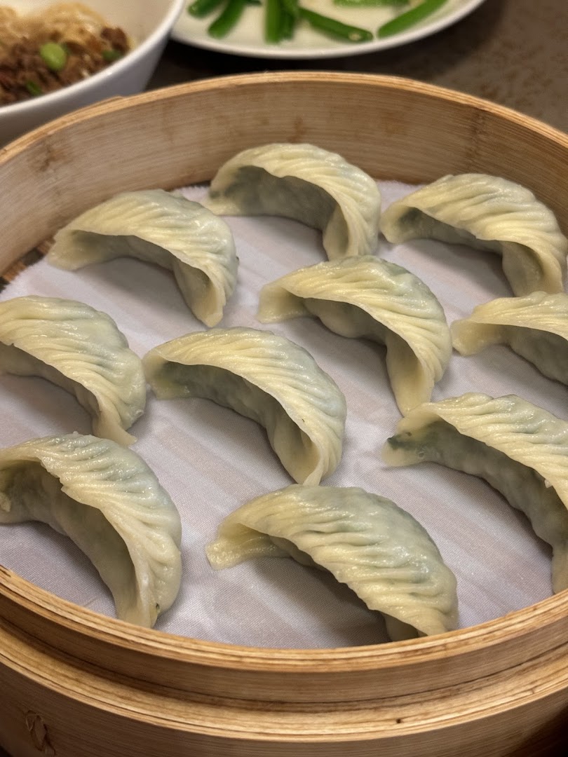 A bamboo steamer filled with freshly steamed dumplings, showcasing Din Tai Fung's culinary delights.