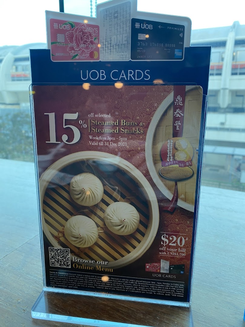 A promotional stand at Din Tai Fung showcasing UOB card offers on steamed buns and snacks.