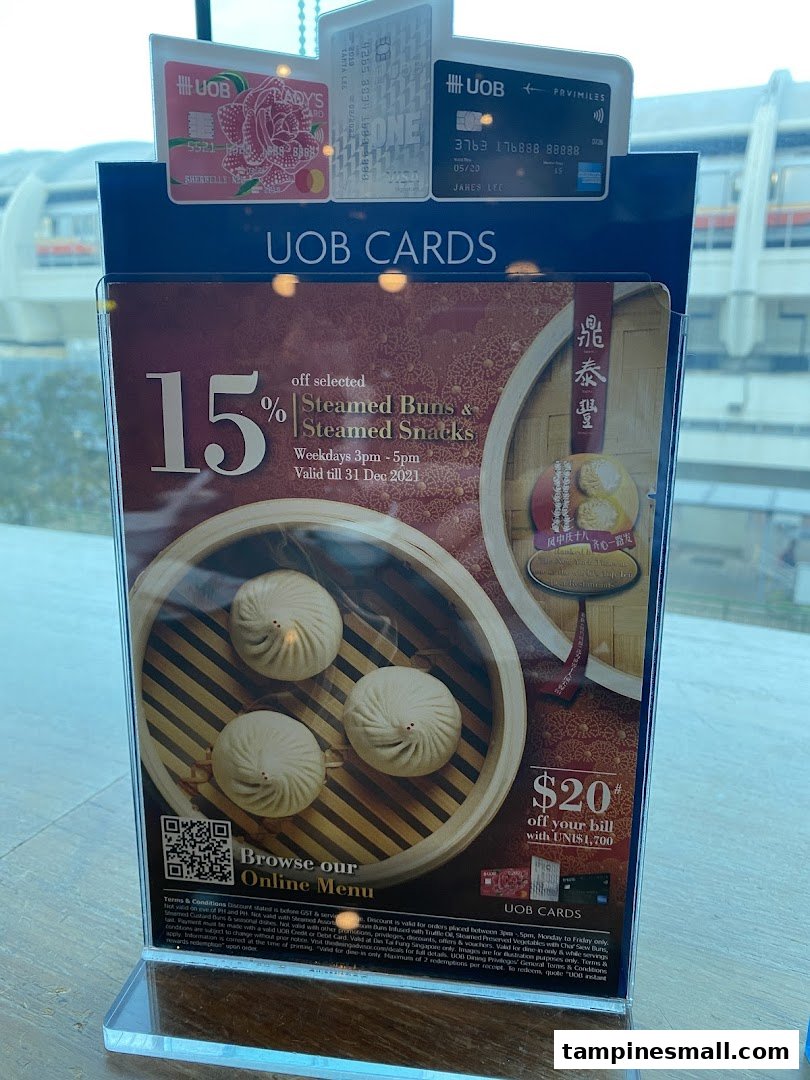 A promotional stand at Din Tai Fung showcasing UOB card offers on steamed buns and snacks.