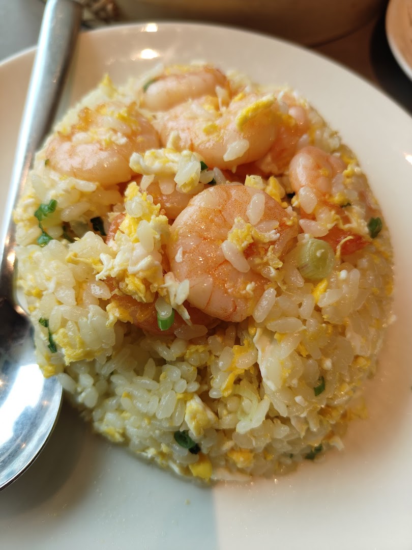 A close-up of delicious shrimp fried rice with scrambled egg and green onions.