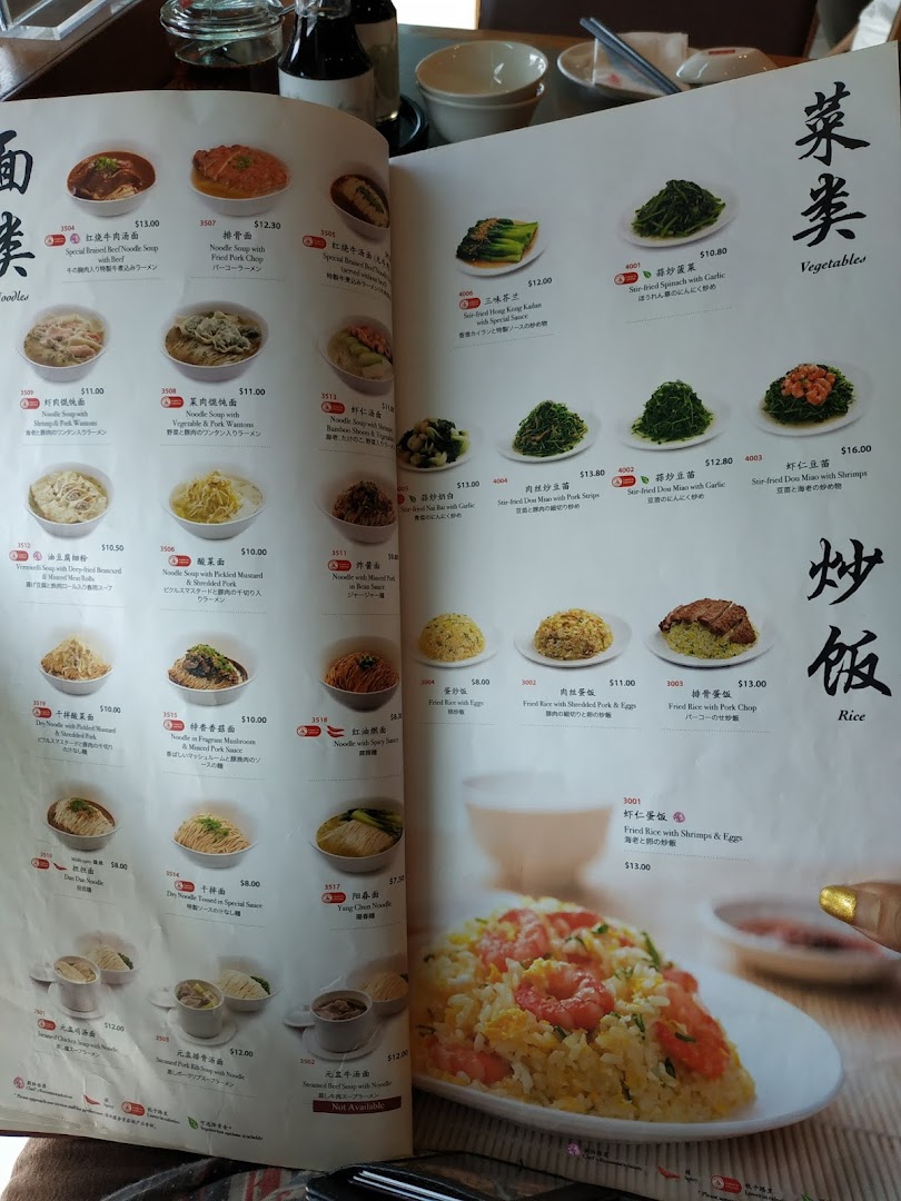 A detailed menu from Din Tai Fung, showcasing a variety of noodles, vegetables, and rice dishes.
