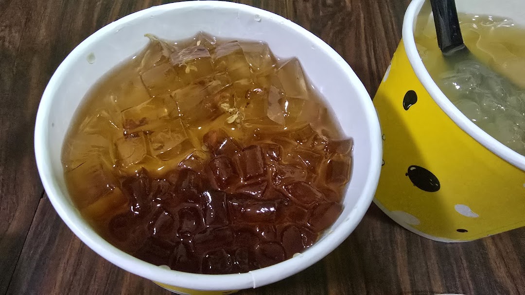 Two cups of refreshing jelly desserts, one prominently featuring amber and dark brown jelly cubes.