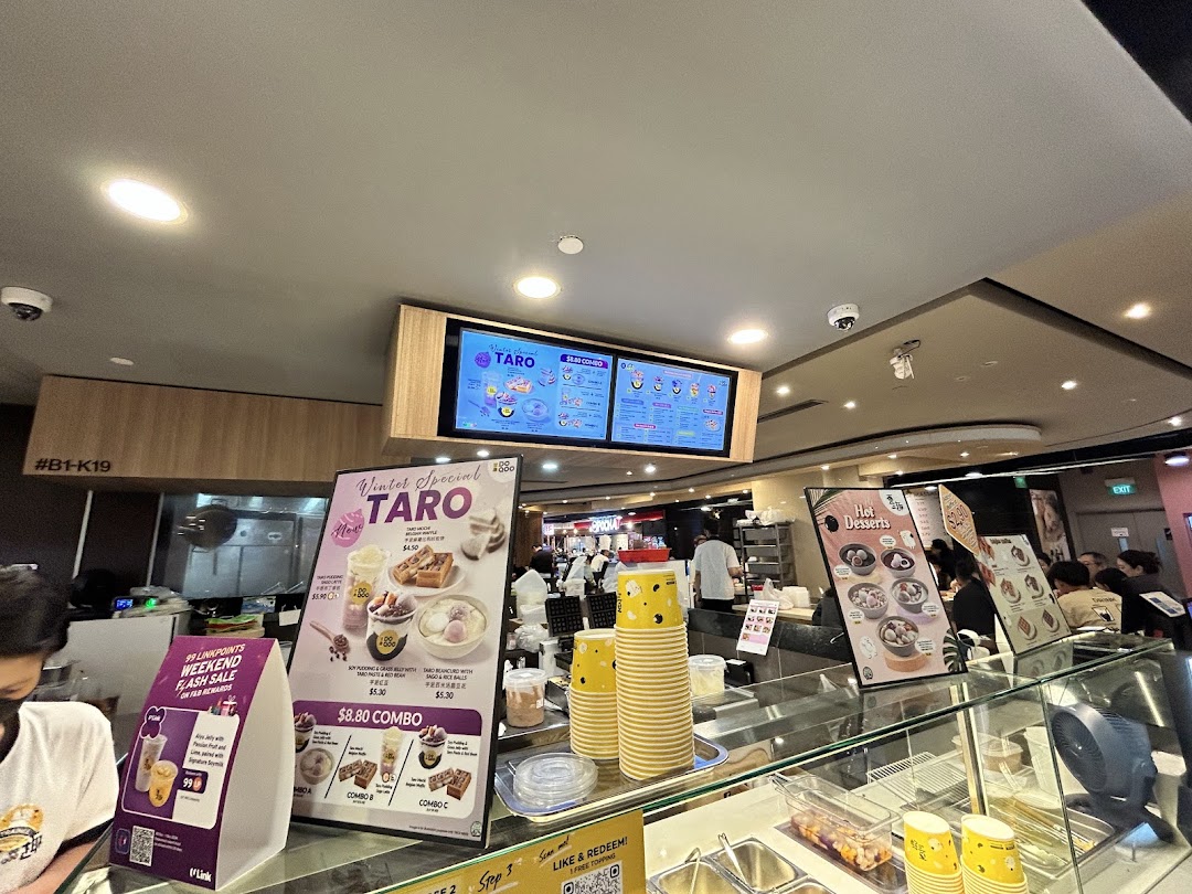 Interior view of Do Qoo dessert shop, featuring digital menus, promotional displays, and counter area.