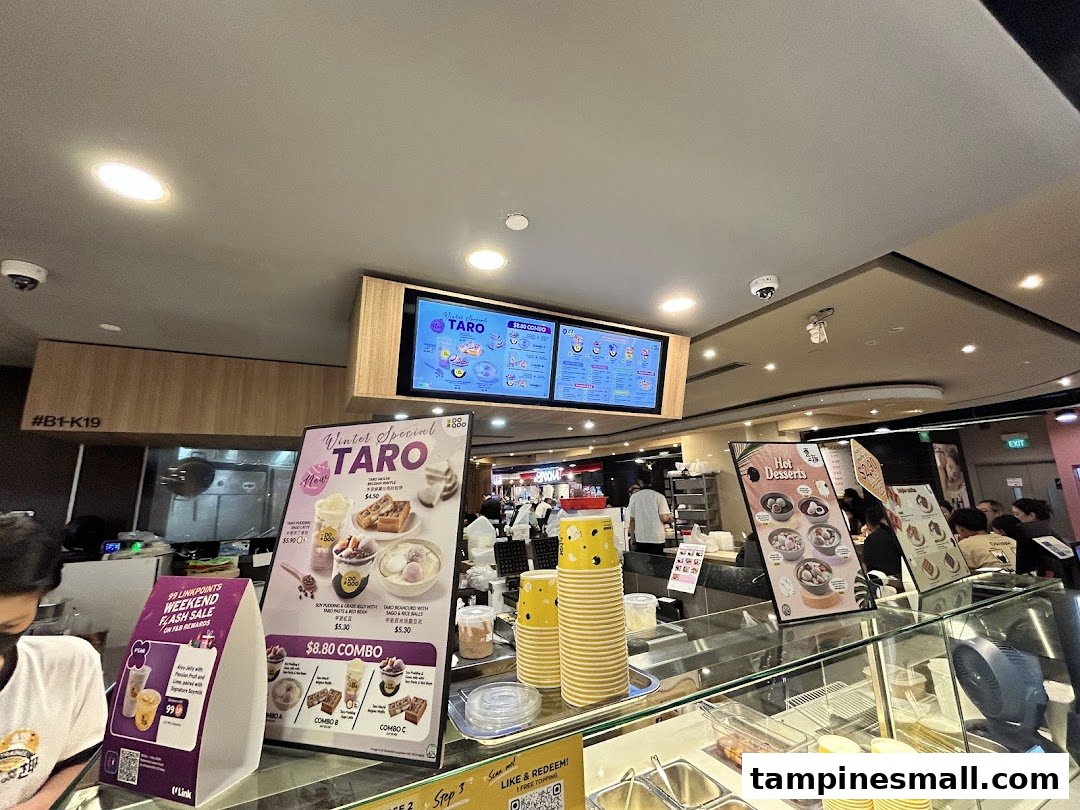Interior view of Do Qoo dessert shop, featuring digital menus, promotional displays, and counter area.